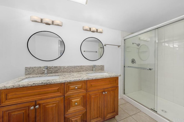 full bathroom featuring tile patterned flooring, a shower stall, and a sink