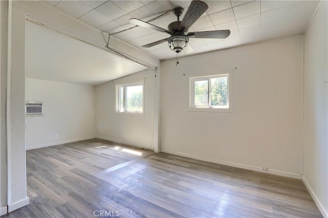 empty room with vaulted ceiling, baseboards, a ceiling fan, and wood finished floors