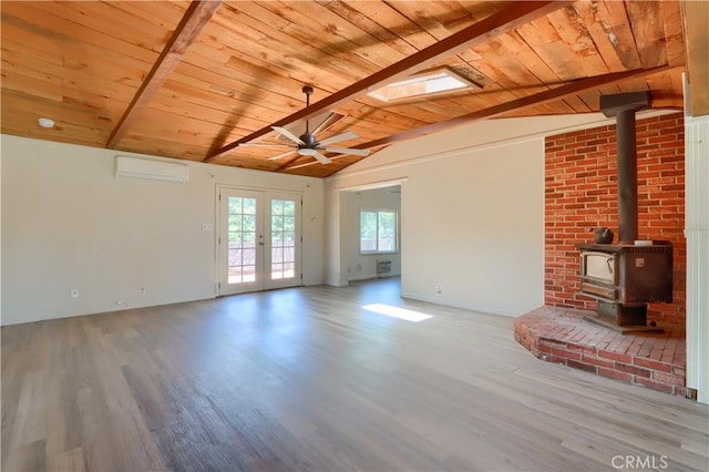 unfurnished living room with lofted ceiling with beams, a wall unit AC, wood ceiling, and wood finished floors