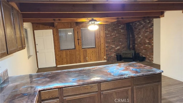 31194 Outer Highway 18 N, Running Springs, CA 92382 - living room featuring a wood stove, beamed ceiling, wood finished floors, wooden walls, and baseboards