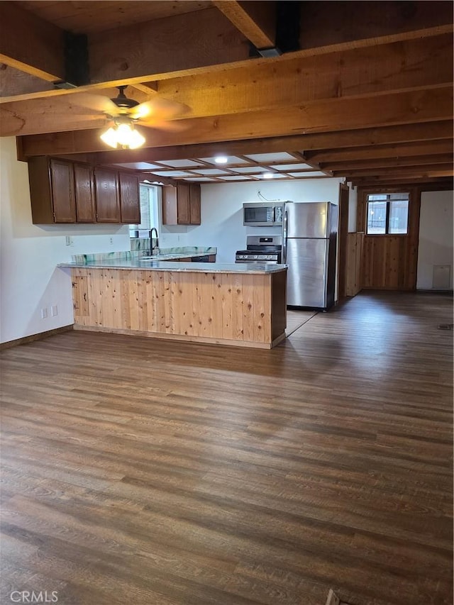 31194 Outer Highway 18 N, Running Springs, CA 92382 - kitchen with stainless steel appliances, a peninsula, dark wood-type flooring, beam ceiling, and baseboards