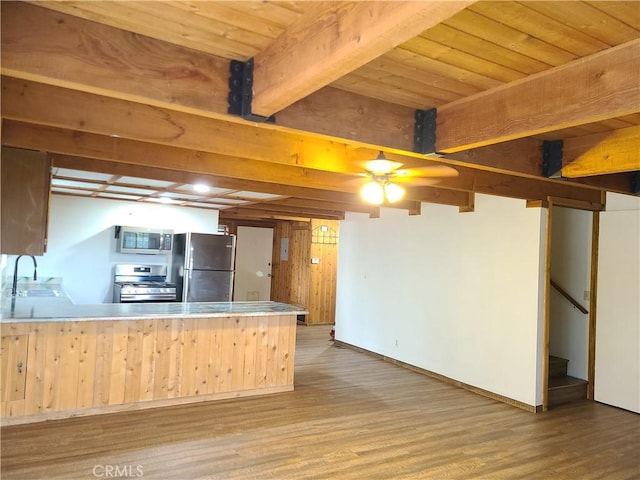 31194 Outer Highway 18 N, Running Springs, CA 92382 - kitchen with appliances with stainless steel finishes, a peninsula, wood finished floors, a sink, and wood ceiling with exposed beams