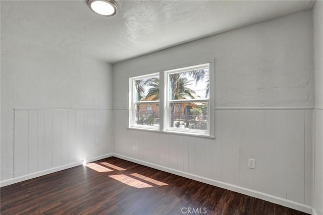 3001 N State St, San Bernardino, CA 92407 - unfurnished room with dark wood finished floors, baseboards, and wainscoting