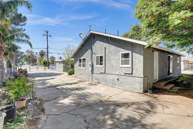 3001 N State St, San Bernardino, CA 92407 - view of side of home featuring stucco siding and fence