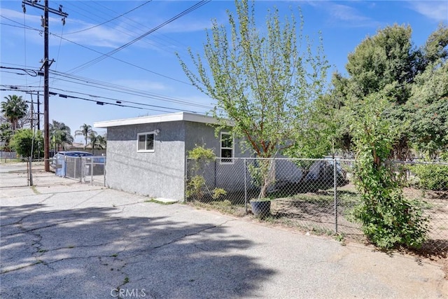 3001 N State St, San Bernardino, CA 92407 - view of side of home featuring a gate, fence, and stucco siding