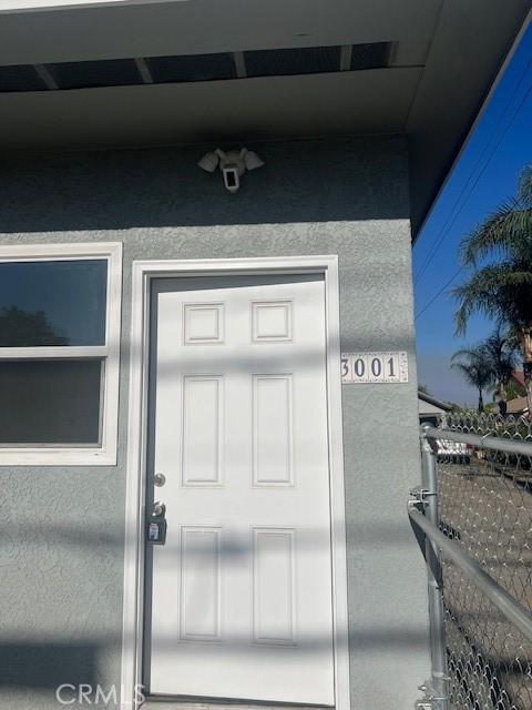 3001 N State St, San Bernardino, CA 92407 - property entrance featuring stucco siding and fence