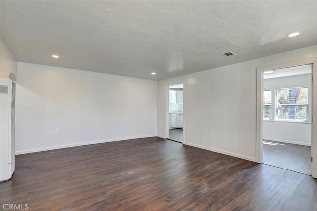 3001 N State St, San Bernardino, CA 92407 - empty room featuring a heating unit, recessed lighting, baseboards, visible vents, and dark wood-style floors