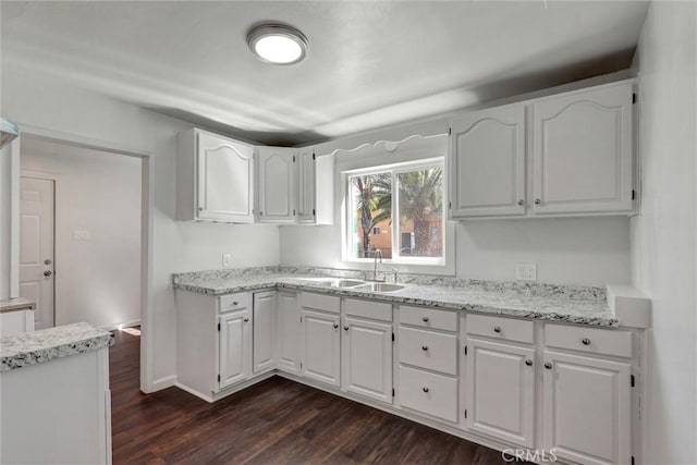 3001 N State St, San Bernardino, CA 92407 - kitchen featuring a sink, light stone counters, white cabinetry, dark wood-style floors, and baseboards