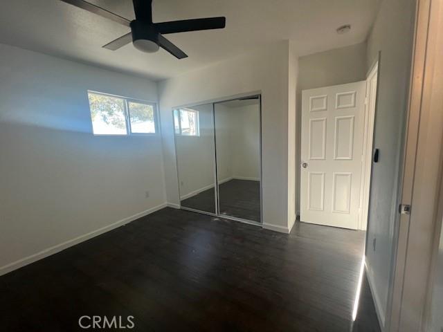3001 N State St, San Bernardino, CA 92407 - unfurnished bedroom with baseboards, a closet, a ceiling fan, and dark wood-style floors