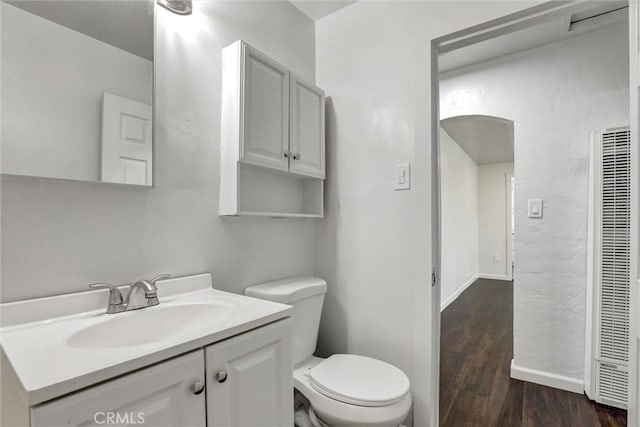 3001 N State St, San Bernardino, CA 92407 - bathroom with a heating unit, toilet, baseboards, vanity, and wood finished floors