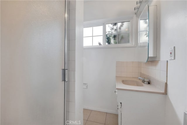 bathroom featuring a shower with shower door, baseboards, tile patterned flooring, tasteful backsplash, and vanity