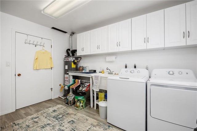 25805 Musselburgh Dr, Menifee, CA 92586 - laundry room with washer and dryer, cabinet space, wood finished floors, and water heater