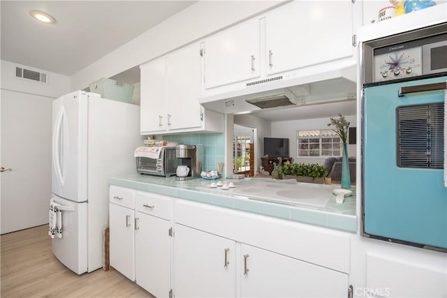 25805 Musselburgh Dr, Menifee, CA 92586 - kitchen featuring white appliances, white cabinetry, tile countertops, light wood-type flooring, and backsplash