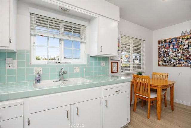 25805 Musselburgh Dr, Menifee, CA 92586 - kitchen with tile countertops, a sink, and white cabinets