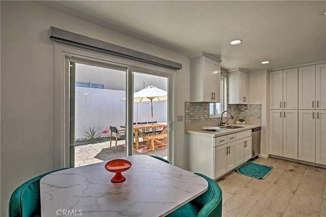 54345 Avenida Carranza Ln, Quinta, CA 92253 - kitchen with a sink, white cabinetry, backsplash, light wood-style floors, and recessed lighting