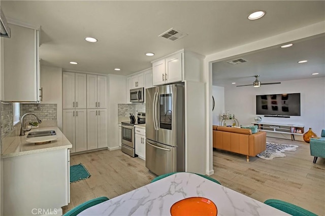 54345 Avenida Carranza Ln, Quinta, CA 92253 - kitchen featuring light wood-type flooring, visible vents, appliances with stainless steel finishes, and a sink