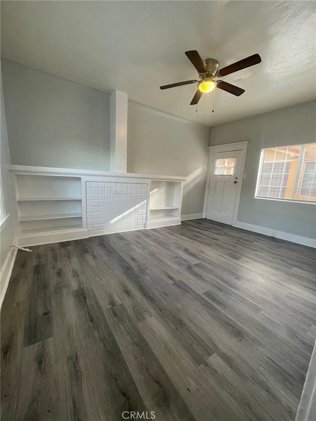 interior space with baseboards, a ceiling fan, and wood finished floors