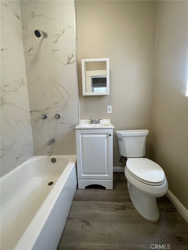 bathroom featuring toilet, baseboards, vanity, and wood finished floors