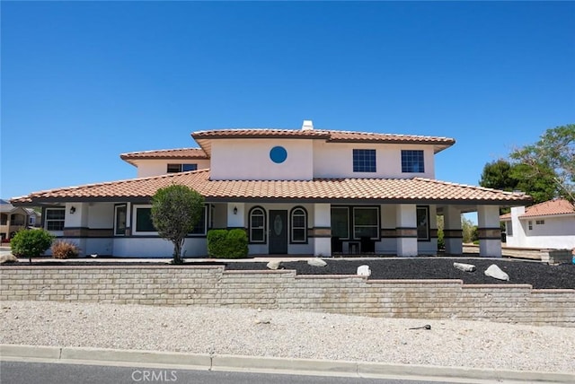 mediterranean / spanish-style house with stucco siding, a tiled roof, and covered porch