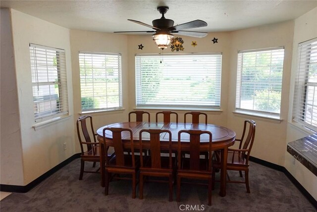 carpeted dining area with baseboards and ceiling fan