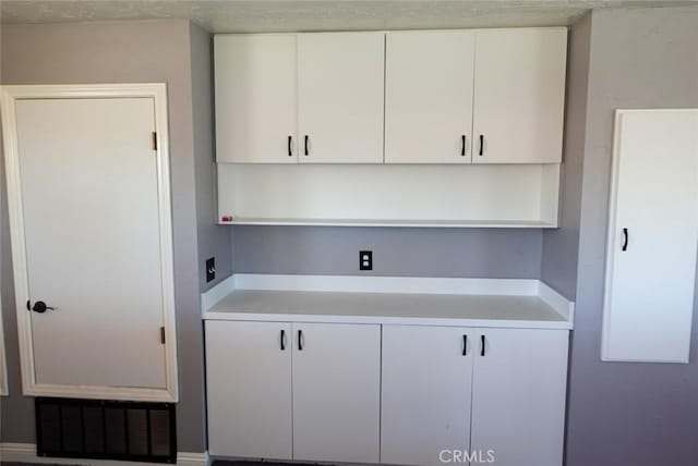 kitchen featuring light countertops, white cabinets, and open shelves