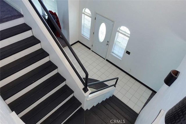 entrance foyer featuring stairway, plenty of natural light, and light tile patterned floors