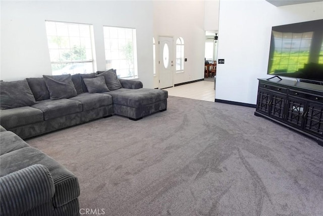 carpeted living area featuring baseboards