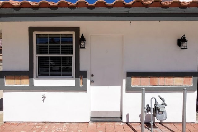 entrance to property with stucco siding and covered porch