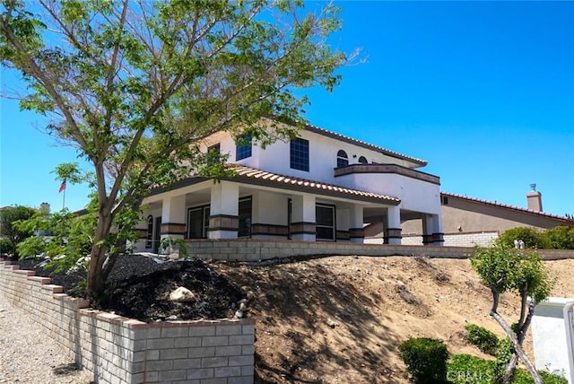 mediterranean / spanish home with stucco siding and a tiled roof