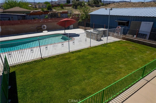 community pool with a patio area, fence, a mountain view, and a lawn