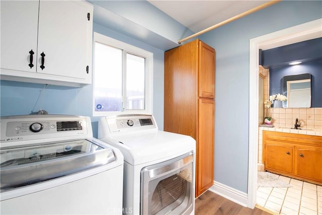 laundry room featuring cabinet space, washing machine and clothes dryer, and baseboards
