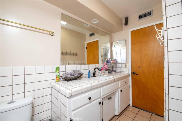 bathroom featuring toilet, tasteful backsplash, vanity, visible vents, and tile patterned floors