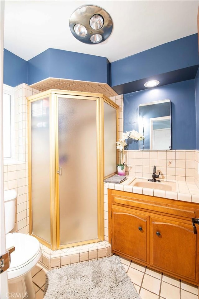 full bathroom with tile patterned flooring, toilet, a shower stall, and vanity