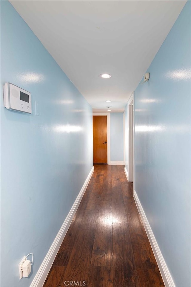 hallway with recessed lighting, baseboards, and wood finished floors