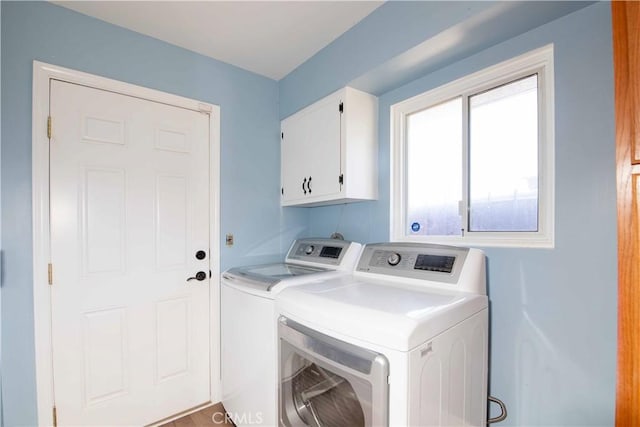 clothes washing area featuring separate washer and dryer and cabinet space