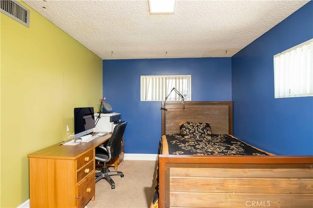 bedroom with a textured ceiling, baseboards, visible vents, and carpet