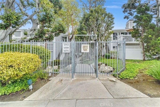 view of gate featuring fence and stairs