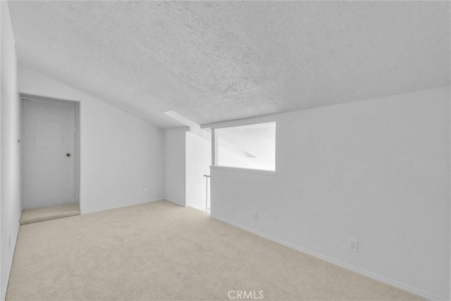 interior space featuring vaulted ceiling, a textured ceiling, and carpet floors