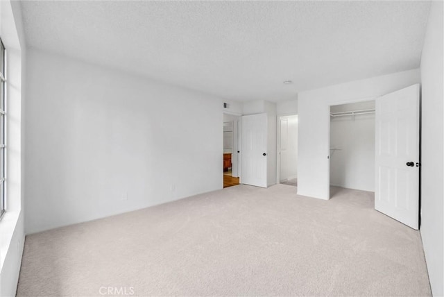 unfurnished bedroom with carpet flooring, a closet, and visible vents