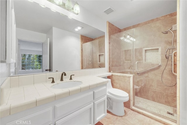 bathroom with vanity, toilet, visible vents, and a shower stall