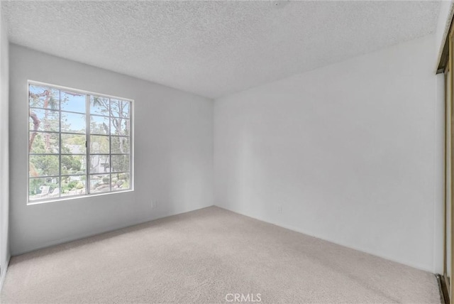 carpeted spare room with a textured ceiling