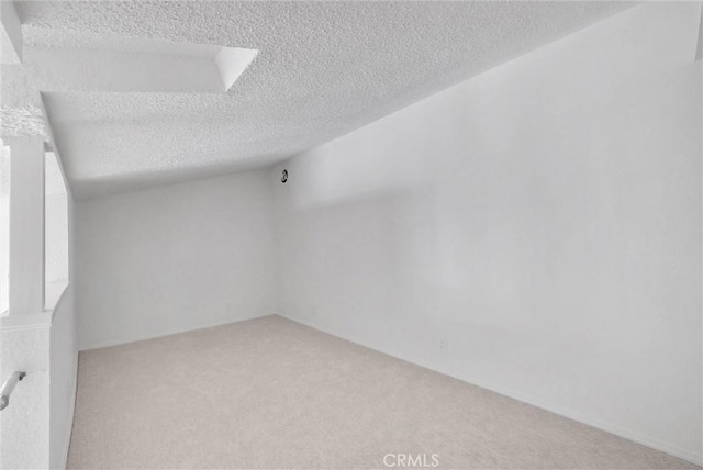 unfurnished room with a textured ceiling and carpet floors