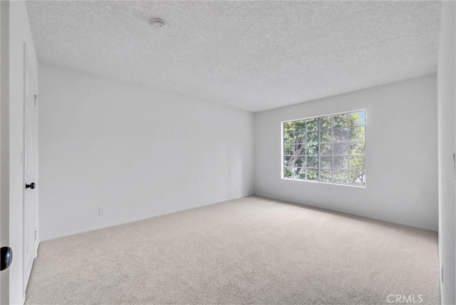 unfurnished room featuring a textured ceiling and carpet floors