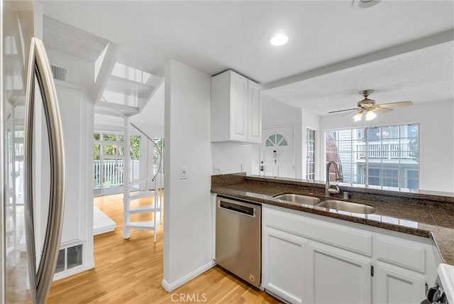 kitchen featuring light wood-style flooring, ceiling fan, a sink, white cabinetry, and stainless steel appliances