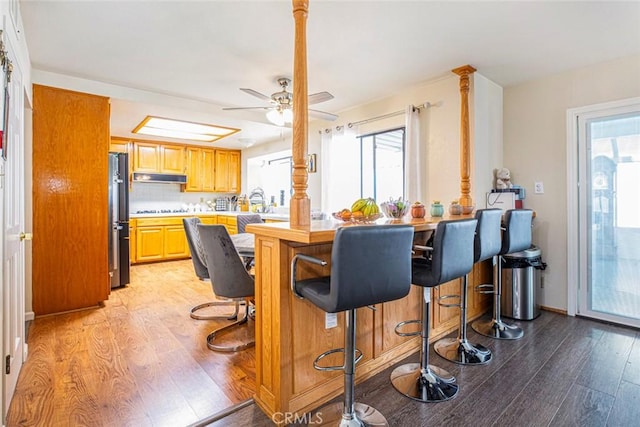 9653 La Tuna Canyon Rd, Sun Valley, CA 91352 - kitchen with under cabinet range hood, freestanding refrigerator, light wood-style flooring, and plenty of natural light