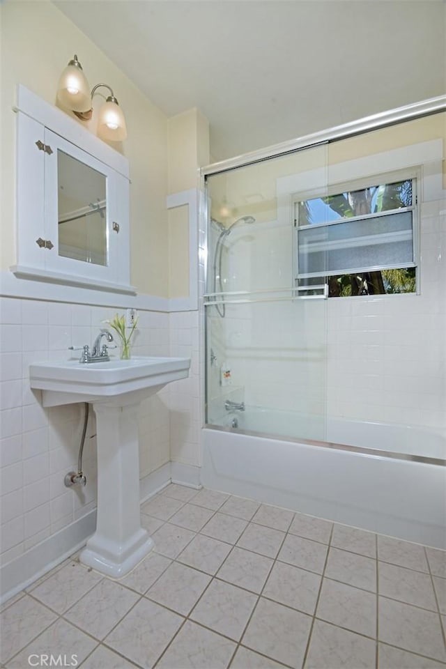 full bathroom featuring tile walls, tile patterned floors, and combined bath / shower with glass door
