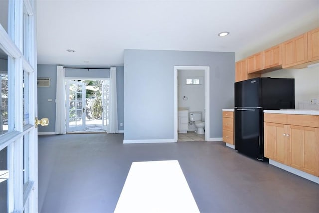 kitchen featuring freestanding refrigerator, baseboards, light brown cabinets, and recessed lighting