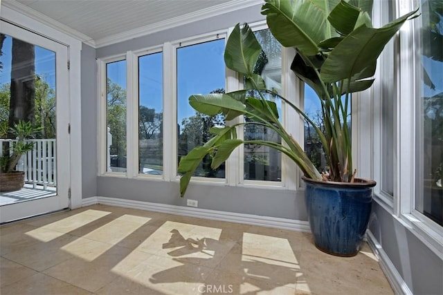 unfurnished sunroom with baseboards, tile patterned flooring, and ornamental molding