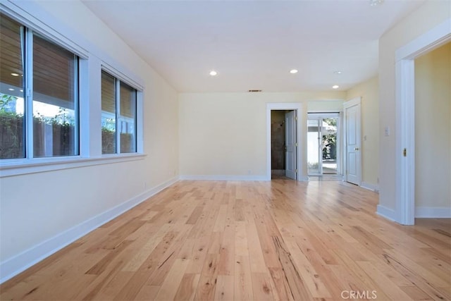 unfurnished room with light wood finished floors, baseboards, visible vents, and recessed lighting