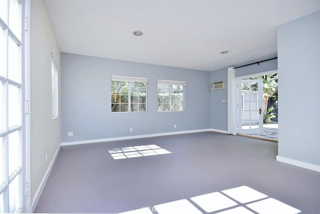 spare room featuring a wall mounted air conditioner, baseboards, and recessed lighting